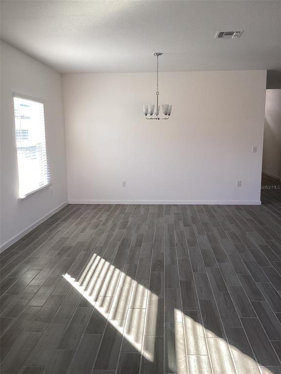 7898 Southwest 74th Loop Ocala, FL 34481 - Photo 6 of 23 an empty room with wooden floor chandelier and windows