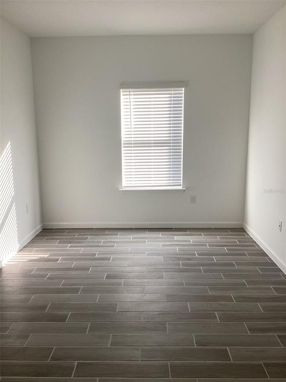 7898 Southwest 74th Loop Ocala, FL 34481 - Photo 7 of 23 a view of an empty room with wooden floor and a window