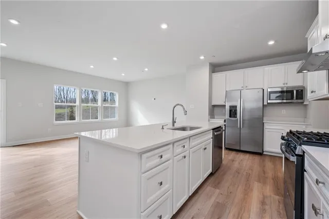 a kitchen with stainless steel appliances a refrigerator sink and stove