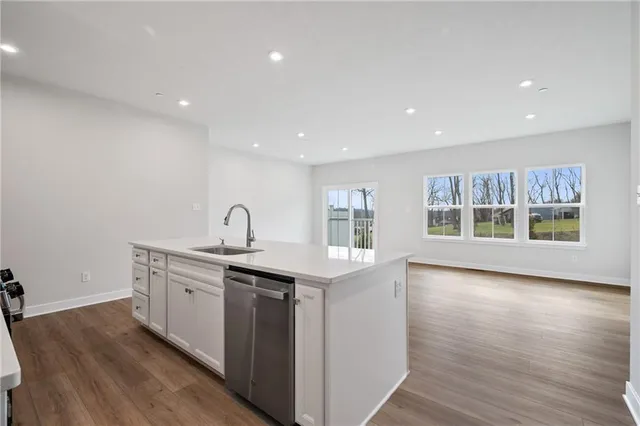 a kitchen with a sink and wooden floor