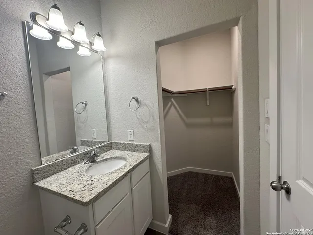 a bathroom with a sink vanity and a mirror