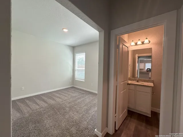 an empty room with wooden floor closet and windows