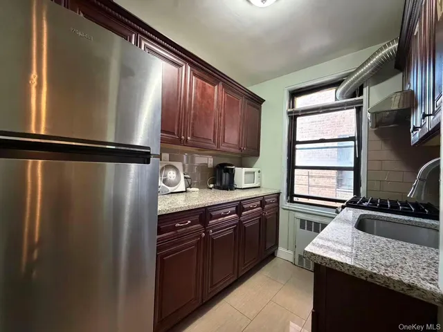 a kitchen with a sink a refrigerator and cabinets