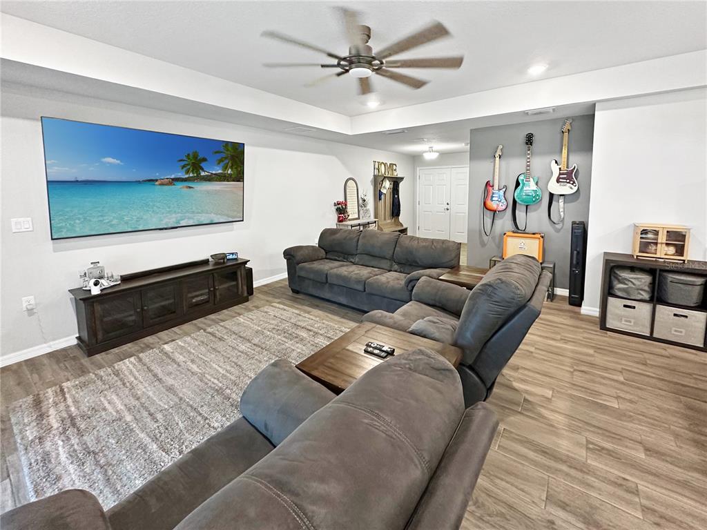 13023 Downy Woodpecker Road Weeki Wachee, FL 34614 - Photo 11 of 43 a living room with furniture and a flat screen tv