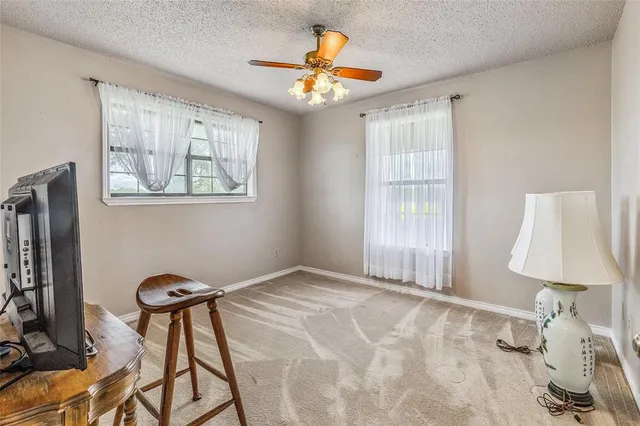 a view of an empty room with a window and a chandelier