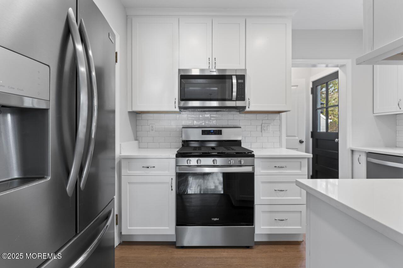 31 Phalanx Road Lincroft, NJ 07738 - Photo 9 of 28 a kitchen with stainless steel appliances a stove a microwave and a refrigerator