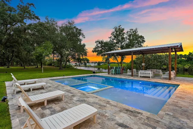 a large kitchen with kitchen island a large counter top space a sink stainless steel appliances and cabinets