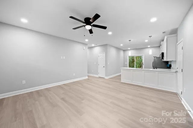 a view of an empty room and kitchen view