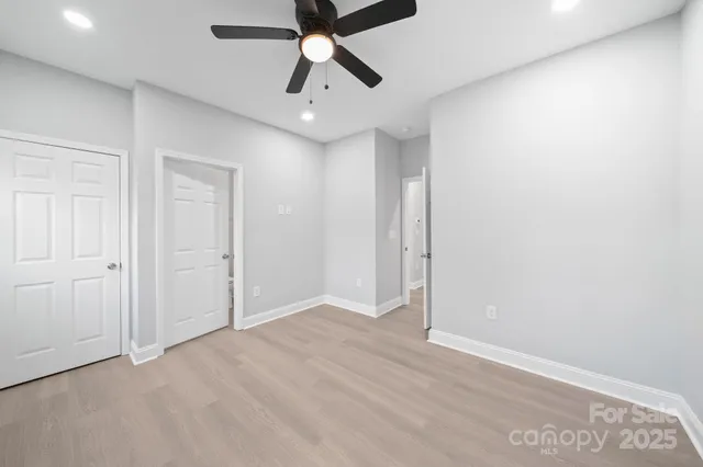 an empty room with chandelier fan