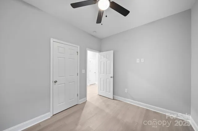 an empty room with chandelier fan