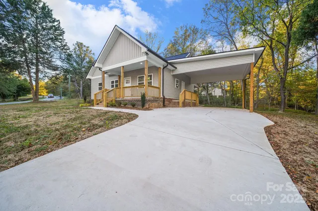a view of a house with a yard and pathway