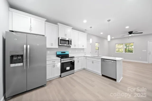 a large kitchen with a refrigerator a stove top oven a sink and dishwasher