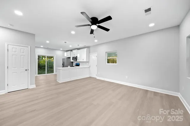 a view of a livingroom with a ceiling fan & wooden floor