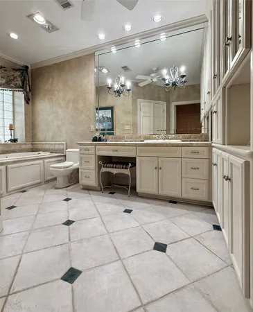a large white kitchen with a large window and cabinets