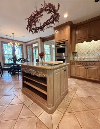 a kitchen with kitchen island granite countertop a stove and a sink with granite countertops