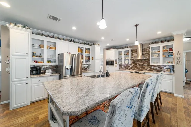 a large kitchen with kitchen island a large island in it
