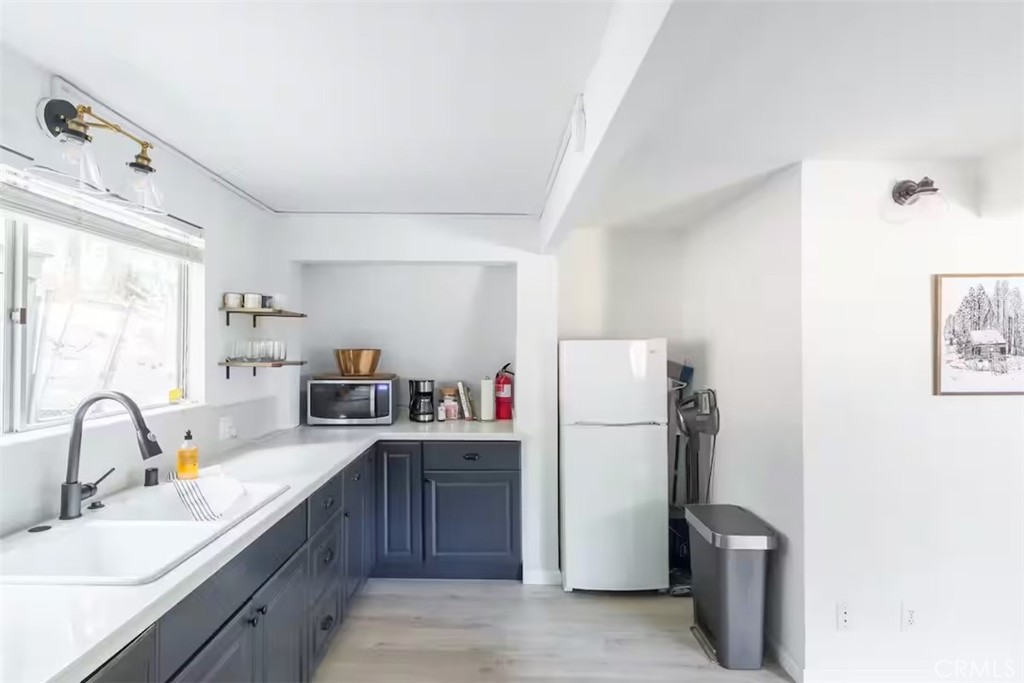 911 Kuffel Canyon Road Lake Arrowhead, CA 92385 - Photo 7 of 23 a room with a sink a refrigerator and a window