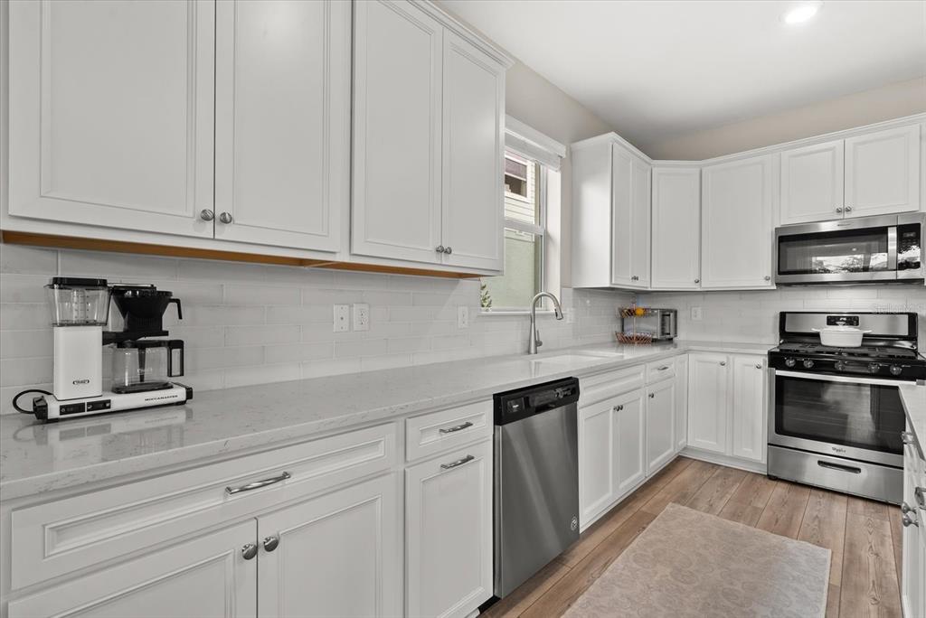 3310 Chestertown Loop Bradenton, FL 34211 - Photo 11 of 71 a kitchen with granite countertop white cabinets and white appliances