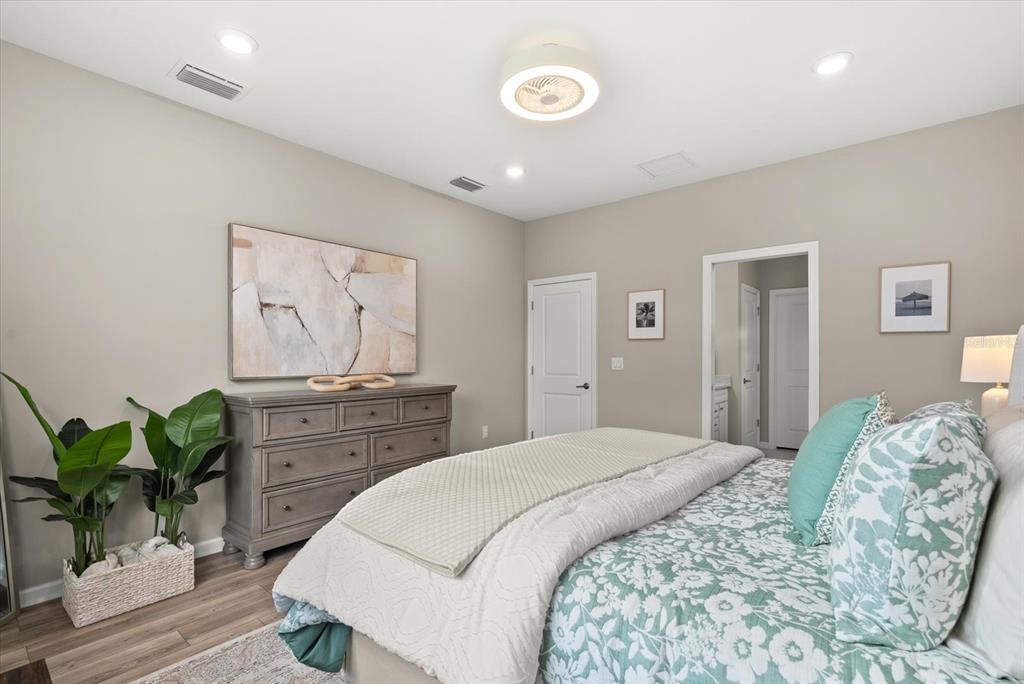 3310 Chestertown Loop Bradenton, FL 34211 - Photo 20 of 71 a spacious bedroom with a bed and a potted plant