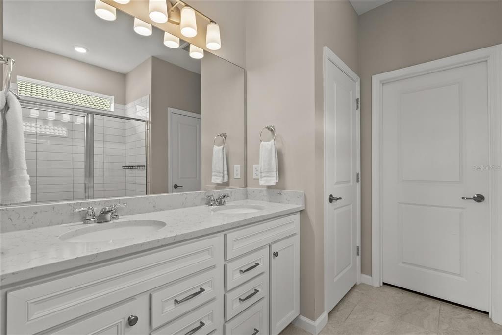 3310 Chestertown Loop Bradenton, FL 34211 - Photo 21 of 71 a bathroom with a granite countertop sink a large mirror and a shower