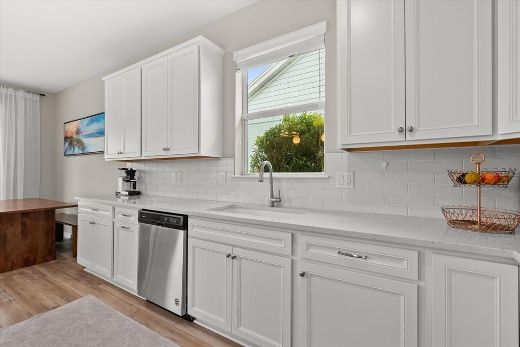 3310 Chestertown Loop Bradenton, FL 34211 - Photo 6 of 71 a kitchen with stainless steel appliances granite countertop white cabinets a sink and dishwasher with wooden floor