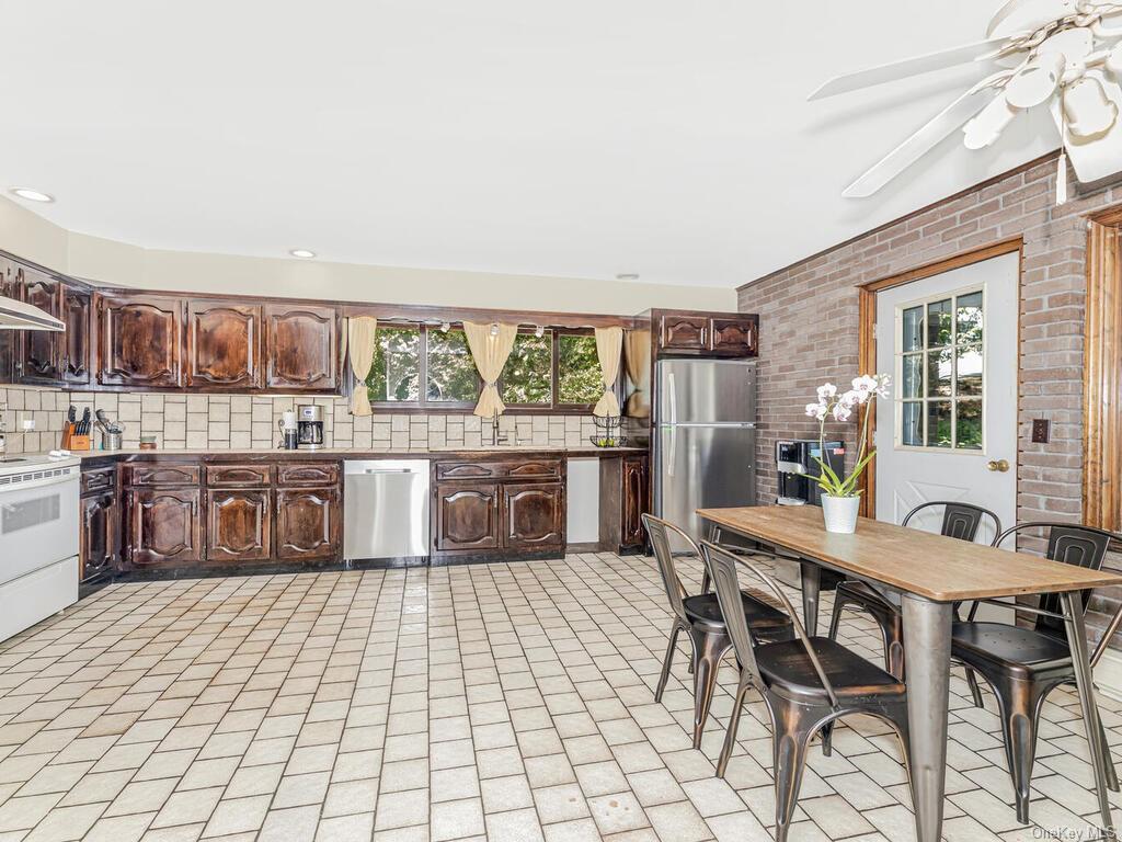 a kitchen with stainless steel appliances a table and chairs in it