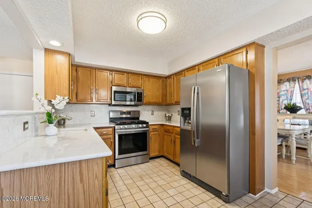 a kitchen with stainless steel appliances granite countertop a refrigerator stove top oven and sink