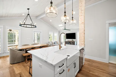a living room with kitchen island furniture and a chandelier