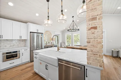 a view of dining room and livingroom with furniture wooden floor a chandelier