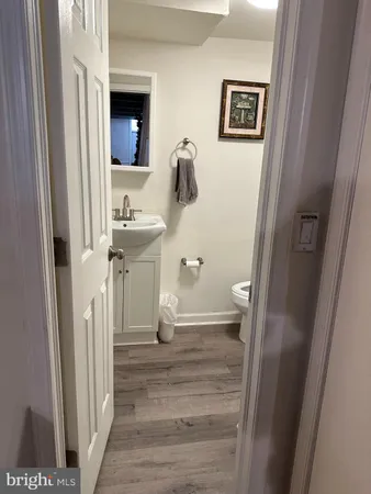 a bathroom with a granite countertop toilet sink and mirror