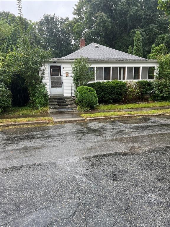 a front view of a house with a yard and trees