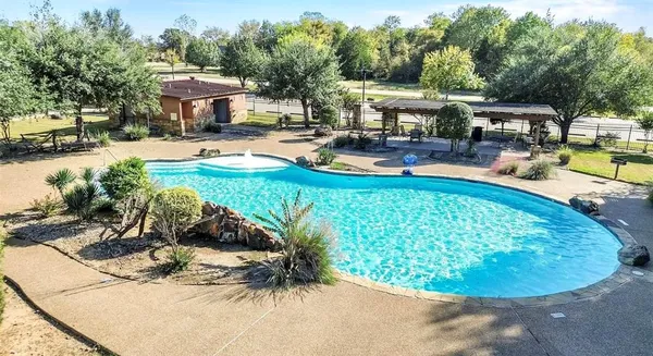 a view of a swimming pool with a patio and plants