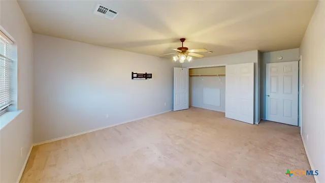 a view of a big room with closet and chandelier fan
