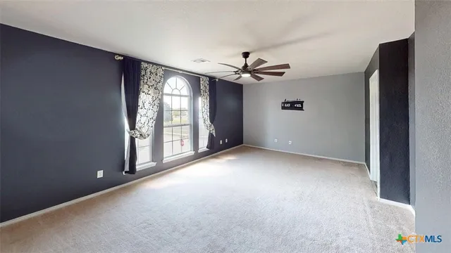 a view of water heater room with floor to ceiling fan