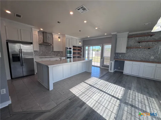 a large kitchen with stainless steel appliances kitchen island granite countertop a large counter top and oven