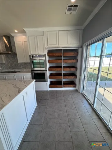 a kitchen with granite countertop a sink and a stove top oven