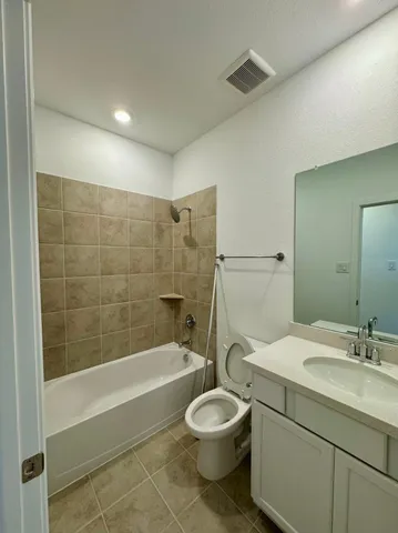 a bathroom with a bathtub shower sink vanity and a toilet