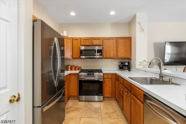 a kitchen with stainless steel appliances granite countertop a refrigerator sink and stove