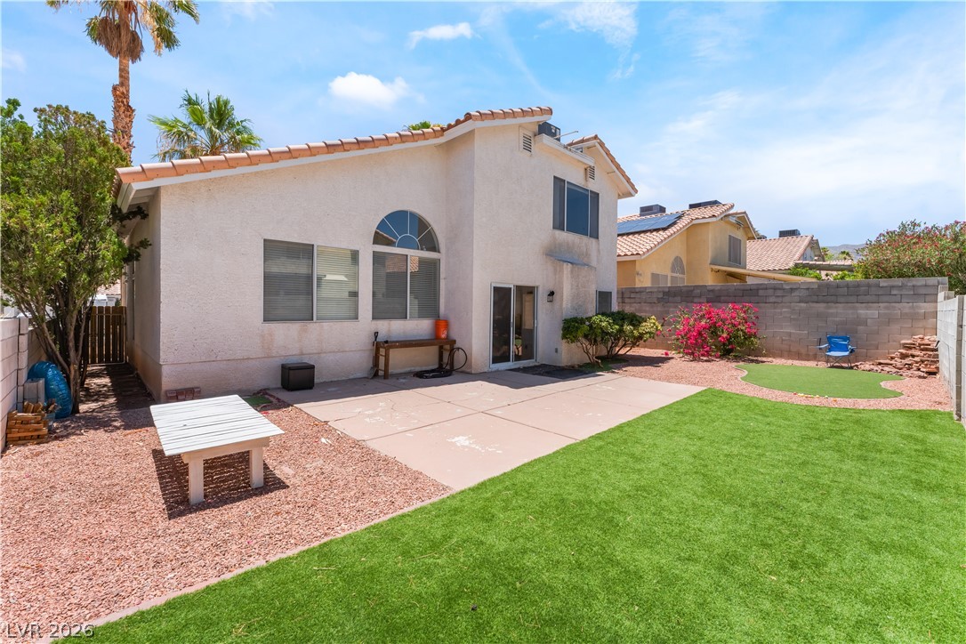 8872 Chapman Point Las Vegas, NV 89129 - Photo 24 of 29 A private yard with a concrete patio and vibrant landscaping offers a tranquil outdoor retreat.