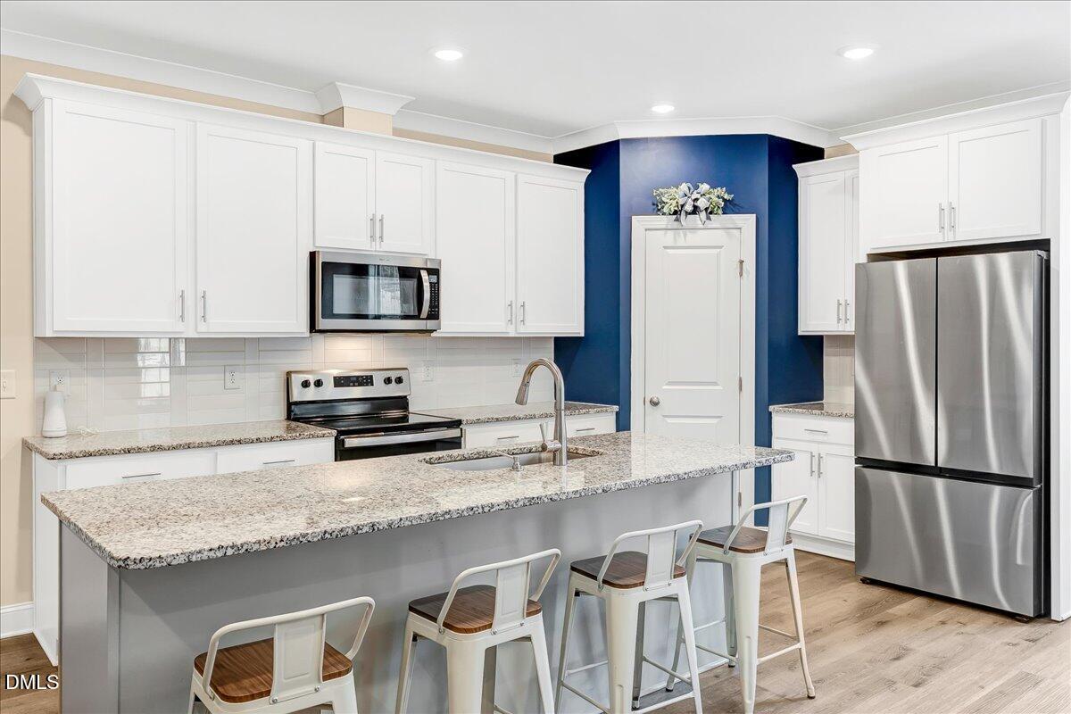 1208 Montgomery Road Franklinton, NC 27525 - Photo 12 of 62 a kitchen with granite countertop stainless steel appliances a refrigerator a stove a sink and a counter