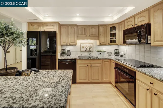 a kitchen with granite countertop a sink and steel appliances