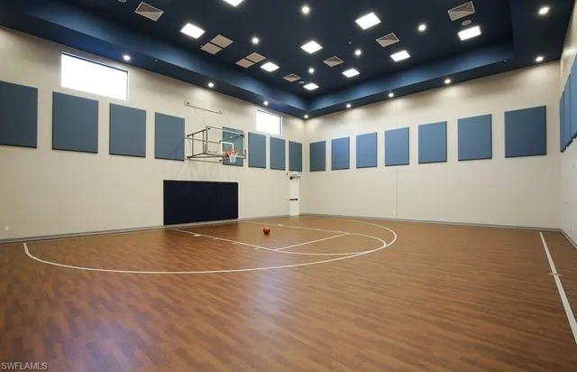 a view of an empty room with wooden floor and windows