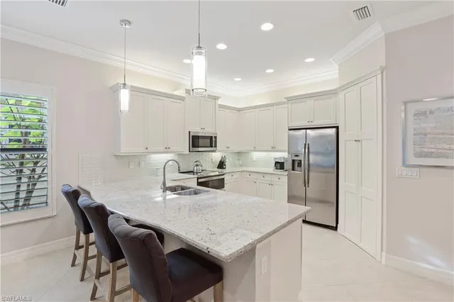 a kitchen with stainless steel appliances granite countertop a kitchen island a stove a table and chairs
