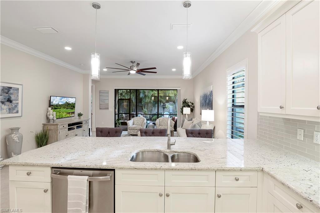 13435 Silktail Drive Naples, FL 34109 - Photo 9 of 27 a kitchen with granite countertop a sink and white cabinets