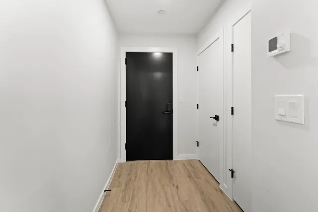 a view of an empty room with closet and a bathroom