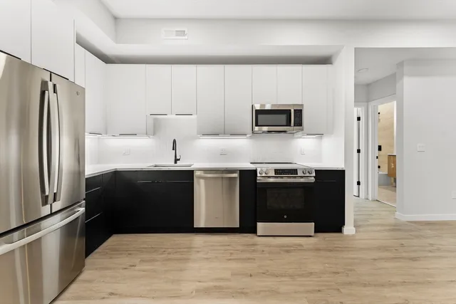 a kitchen with stainless steel appliances granite countertop a refrigerator and a stove
