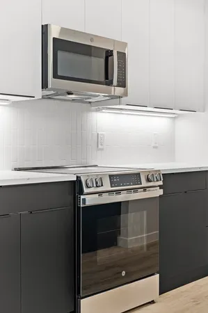 a kitchen with stainless steel appliances granite countertop a stove a microwave and a sink