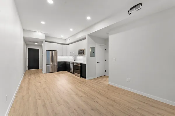 a large white kitchen with a refrigerator a stove and cabinets