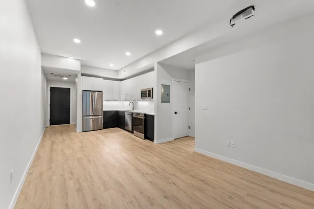 a large white kitchen with a refrigerator a stove and cabinets