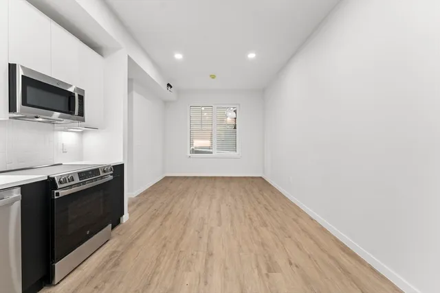a view of a kitchen with wooden floor and electronic appliances